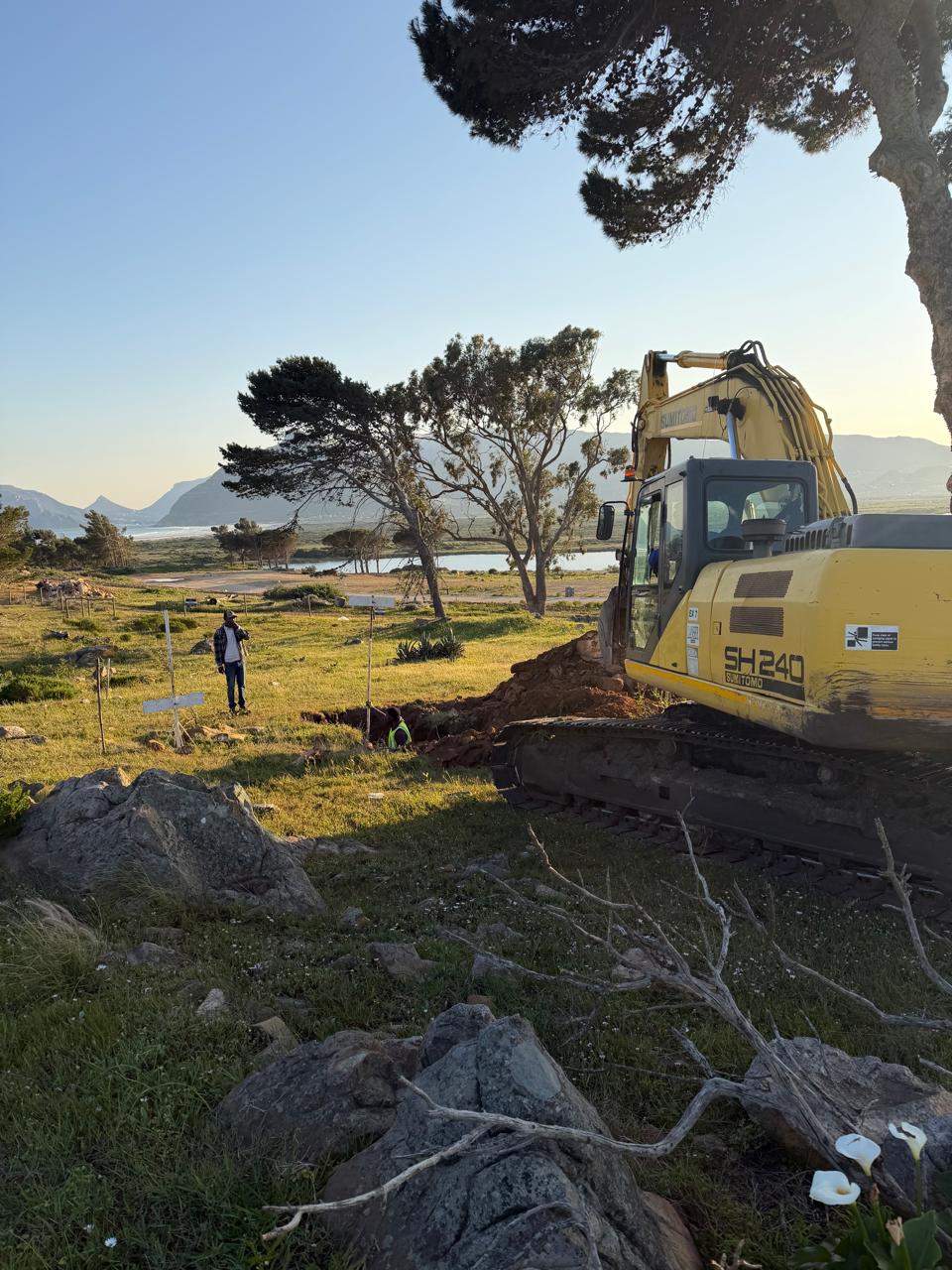 Excavator working on site at Imhoff Manor with mountain and wetland views